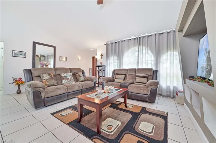 Living area with light tile patterned floors and lofted ceiling