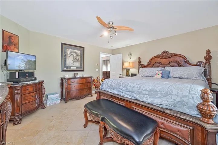 Bedroom with light tile patterned flooring and ceiling fan