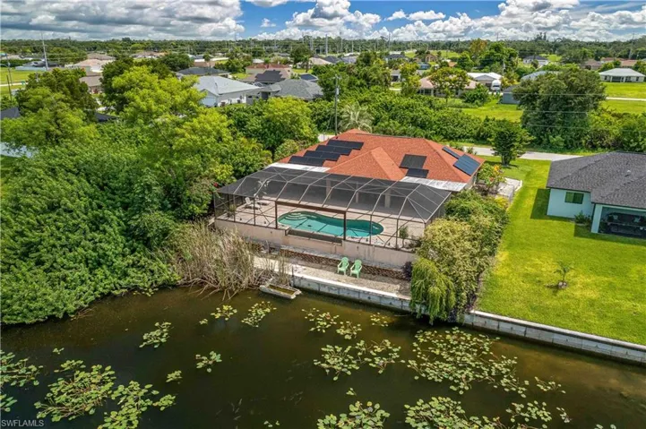 Aerial view of residential area with a nearby body of water and a pool