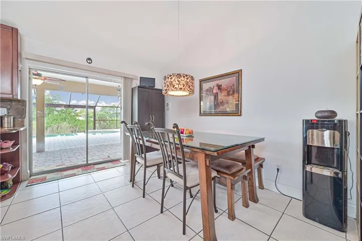 Dining space with light tile patterned floors and vaulted ceiling