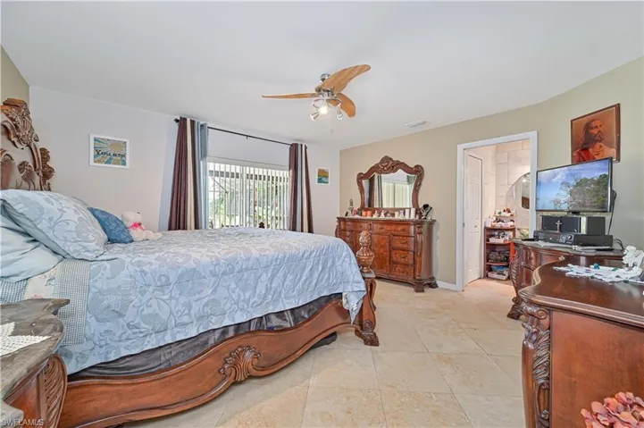 Bedroom with ceiling fan and light tile patterned flooring