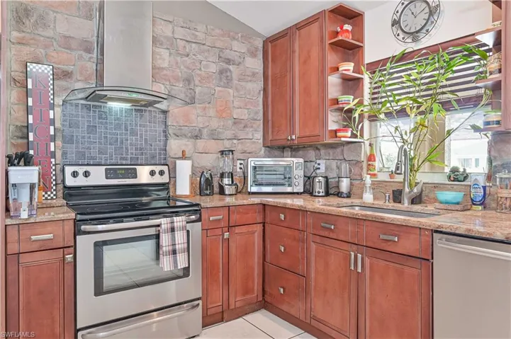 Kitchen with appliances with stainless steel finishes, island range hood, open shelves, decorative backsplash, and vaulted ceiling