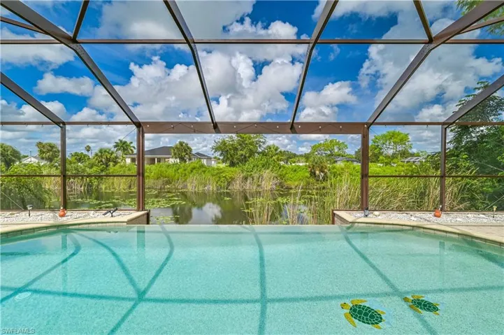 Swimming pool featuring glass enclosure and a water view