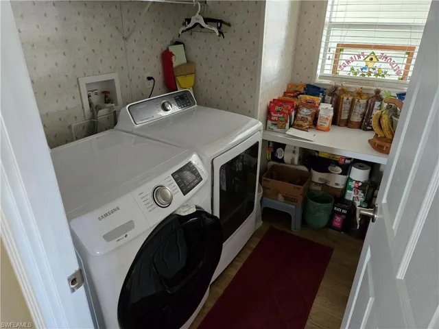 Laundry area featuring washer and clothes dryer and hardwood / wood-style floors