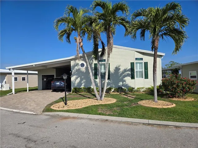 View of front facade featuring a carport and a front yard