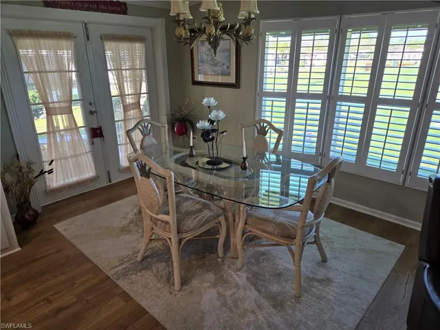 Dining room with dark wood-type flooring and a chandelier