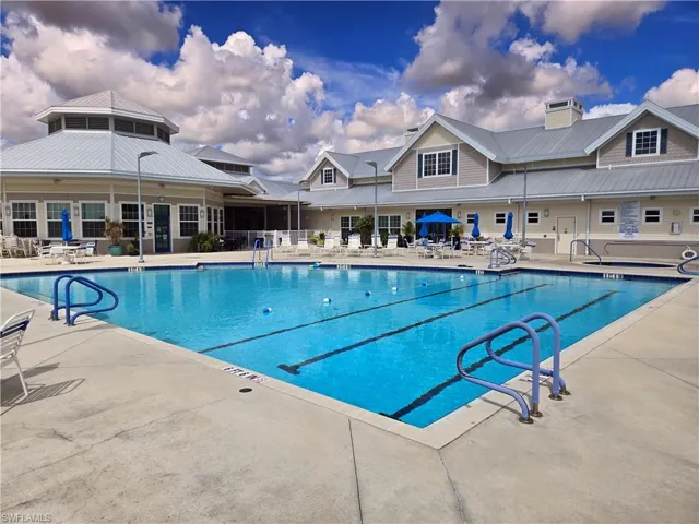 View of pool featuring a wall mounted air conditioner and a patio area