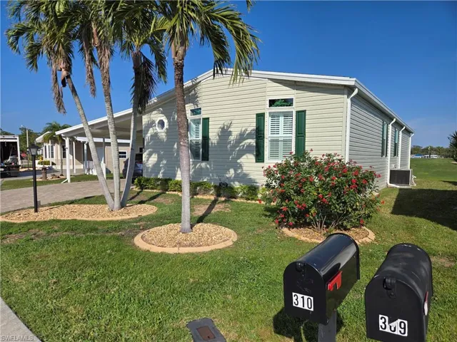 View of front facade featuring a carport and a front yard