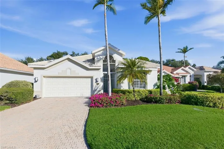 View of front facade with a front lawn, stucco siding, decorative driveway, and an attached garage
