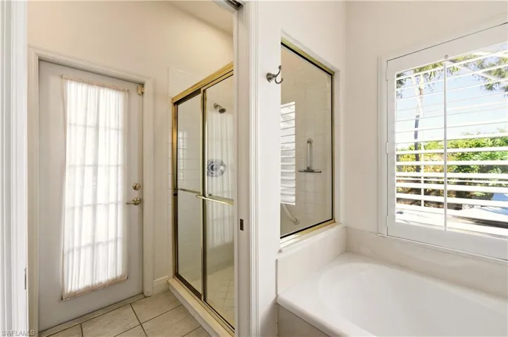 Master Bathroom featuring a stall shower, tub, and light tile patterned floors