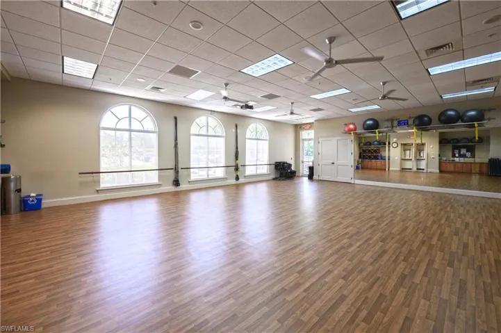 Community Center Exercise area with ceiling fan and a drop ceiling