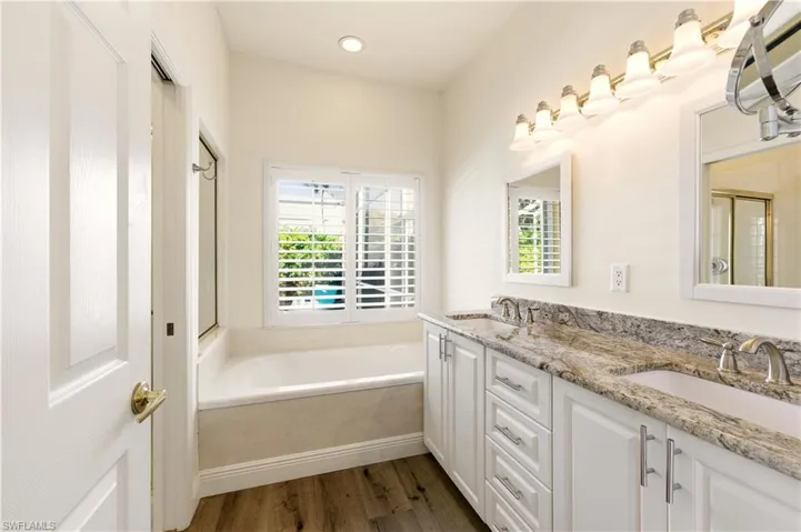 Master Bathroom with  tub, double vanity, a stall shower, Luxury Vinyl flooring, and recessed lighting