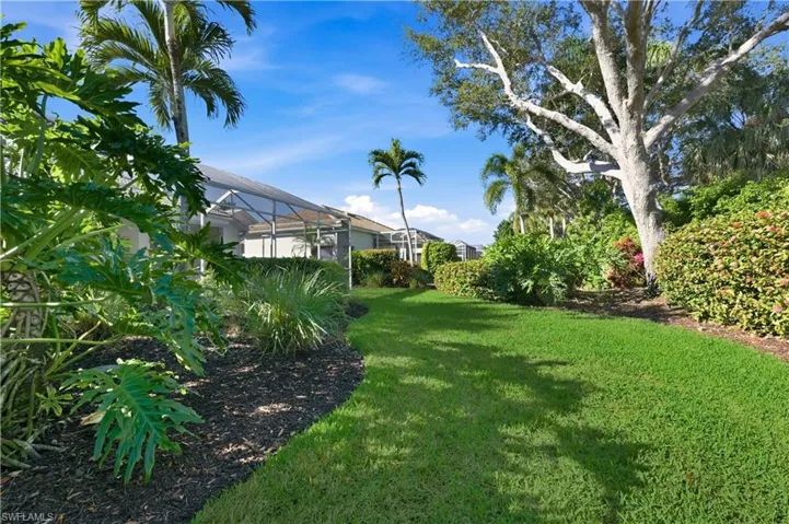 View of Rear yard green lawn with a lanai
