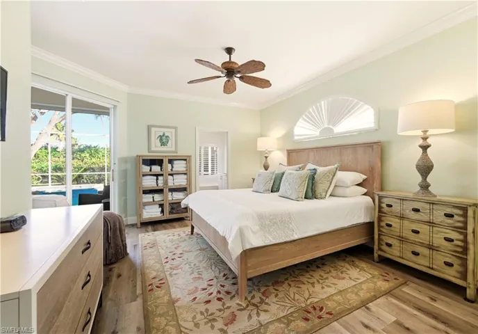 Master Bedroom featuring Luxury Vinyl flooring, ornamental molding, access to exterior, and a ceiling fan