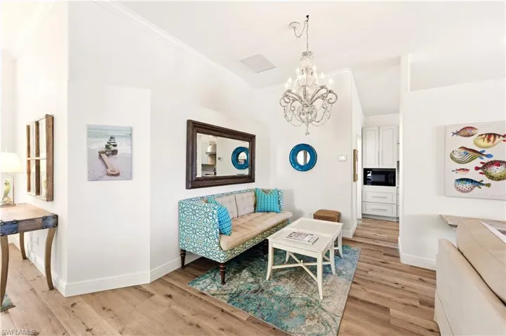 Dining Room with Luxury Vinyl flooring, a chandelier, and crown molding