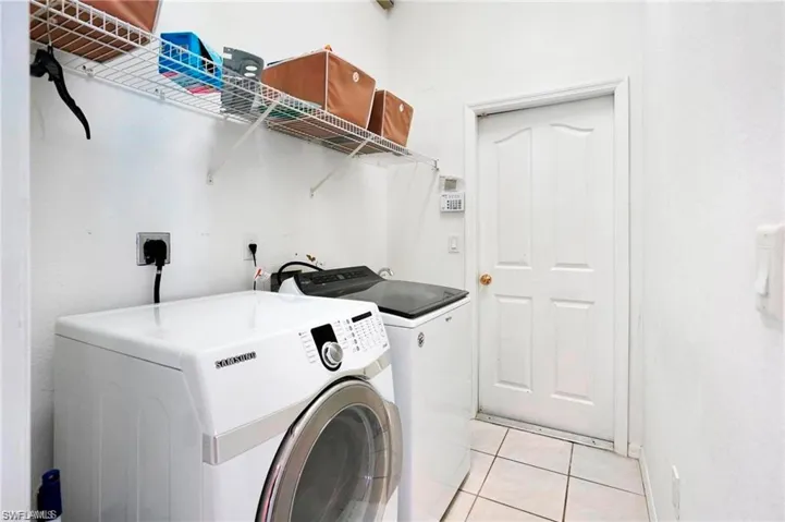 Laundry room featuring light tile patterned flooring and washer and dryer