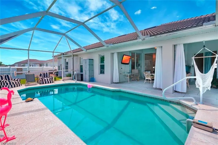 Outdoor pool with a patio, glass enclosure, and a sunroom