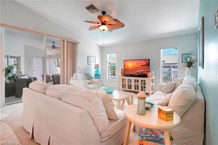 Living room featuring vaulted ceiling and a ceiling fan