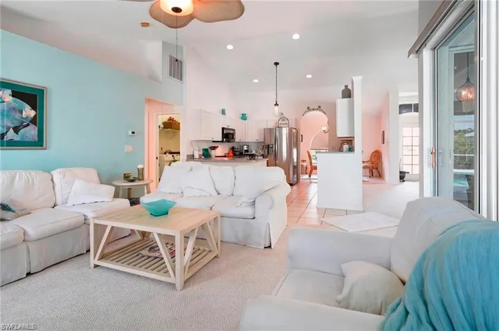 Living area with a ceiling fan, lofted ceiling, recessed lighting, and light tile patterned floors