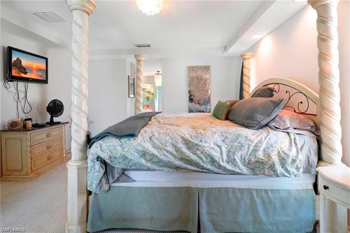 Bedroom featuring decorative columns, carpet floors, and recessed lighting