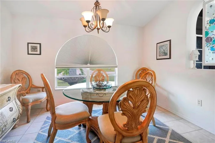 Dining room with light tile patterned floors and hanging lights