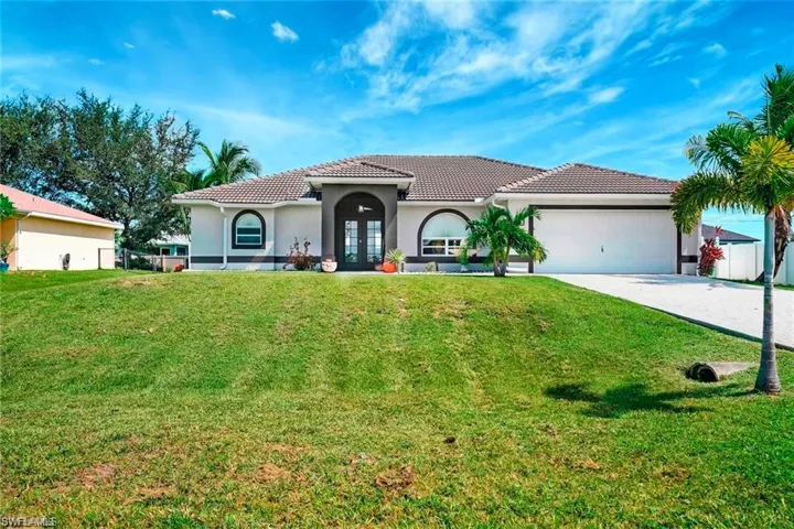 Mediterranean / spanish-style home featuring a front lawn, stucco siding, a tiled roof, and an attached garage