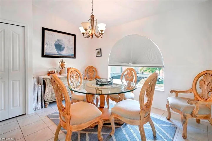 Dining room with light tile patterned floors and hanging lights