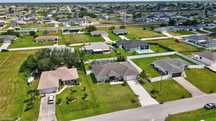 Aerial view of property and surrounding area with nearby suburban area