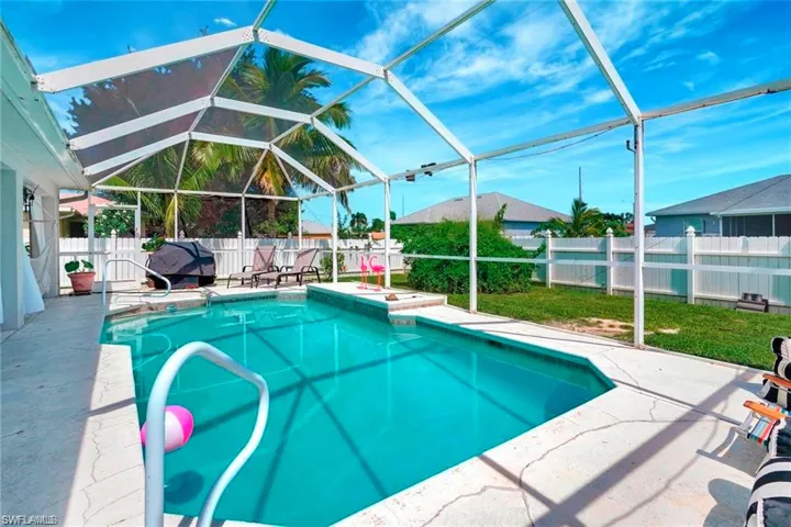View of pool featuring a lanai, a fenced backyard, and a sunroom