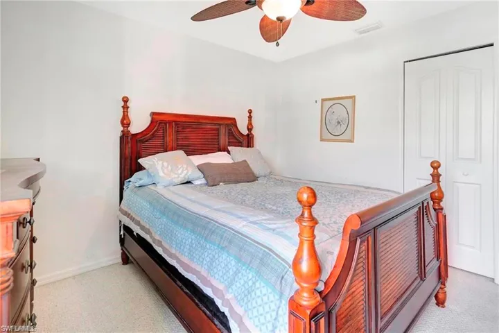 Bedroom featuring ceiling fan, light carpet, and a closet
