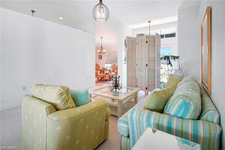 Carpeted living room with suspended lighting