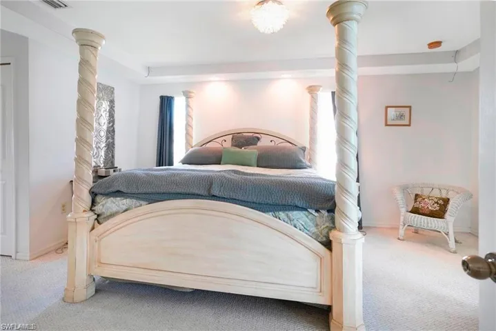 Carpeted bedroom featuring decorative columns and recessed lighting