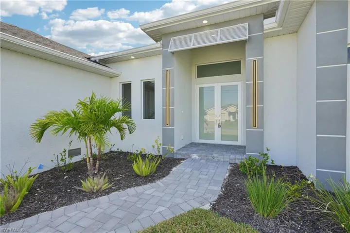 Property entrance featuring stucco siding and french doors