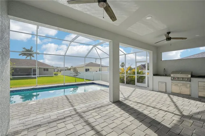 Pool with area for grilling, a lawn, a lanai, a patio, and grilling area