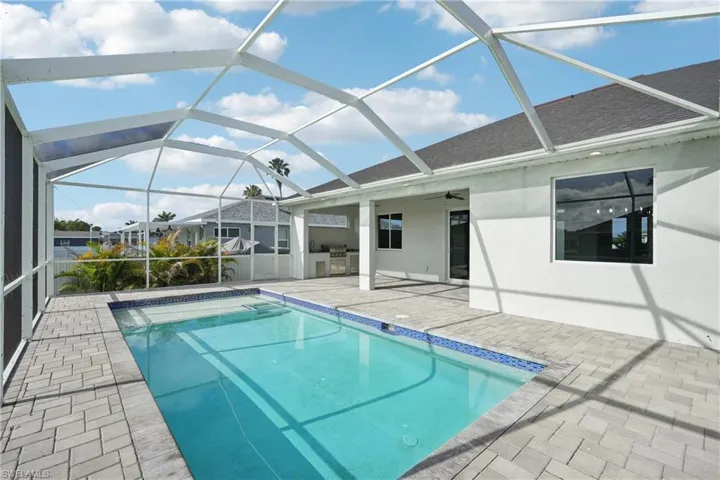 Outdoor pool with a patio, area for grilling, a ceiling fan, and a lanai