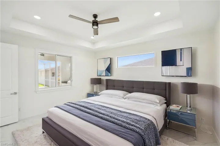 Bedroom featuring marble finish floor, recessed lighting, a ceiling fan, and a raised ceiling