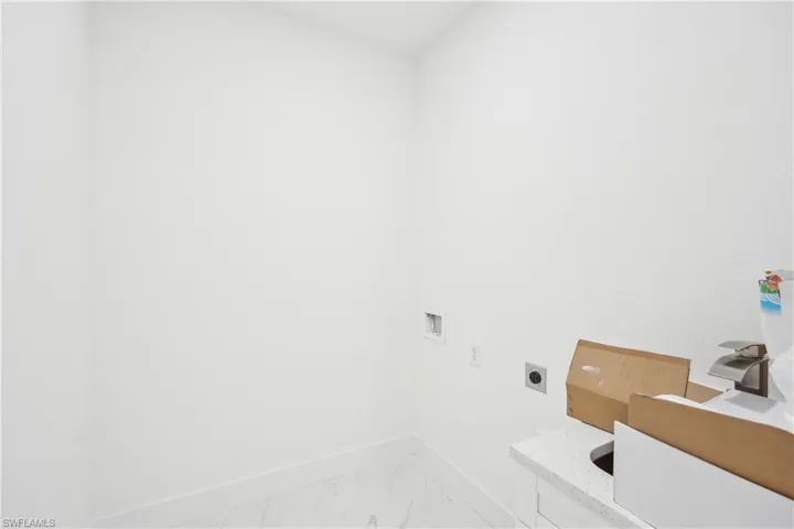 Washroom with hookup for a washing machine, baseboards, marble finish floor, laundry area, and electric dryer hookup
