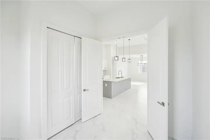 Hallway with marble finish floor and a sink