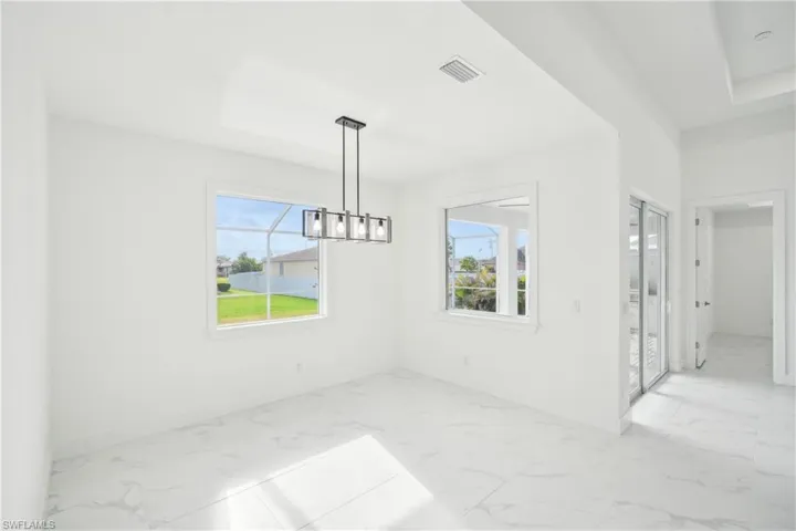 Unfurnished dining area featuring baseboards, marble finish floor, and a notable chandelier