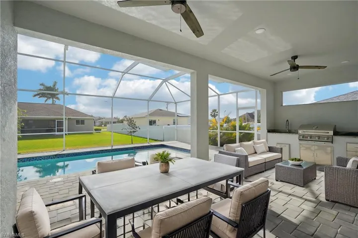 View of patio featuring area for grilling, outdoor lounge area, glass enclosure, and exterior kitchen