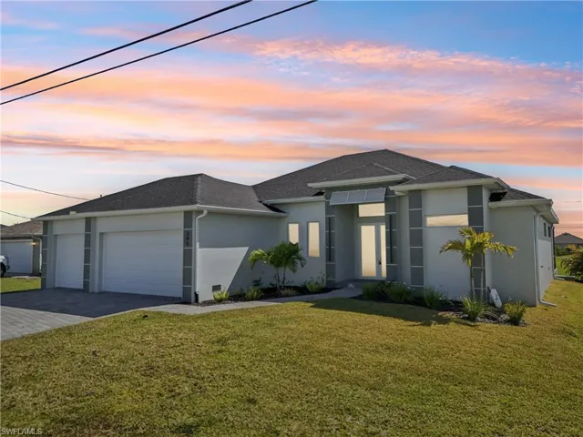 View of front of home featuring a garage, a front yard, decorative driveway, and stucco siding