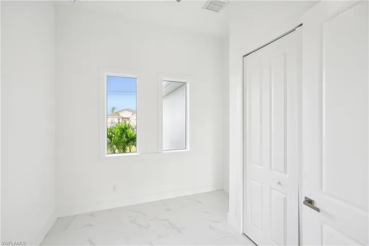 Unfurnished bedroom with baseboards, marble finish floor, visible vents, and a closet