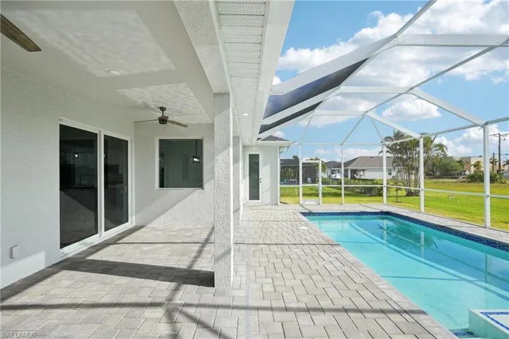 Pool with a lawn, ceiling fan, a lanai, and a patio area