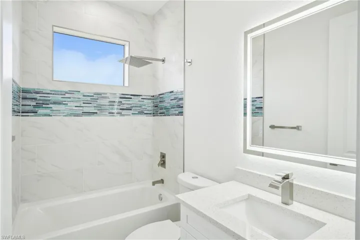 Full bathroom with toilet, vanity, and tub / shower combination