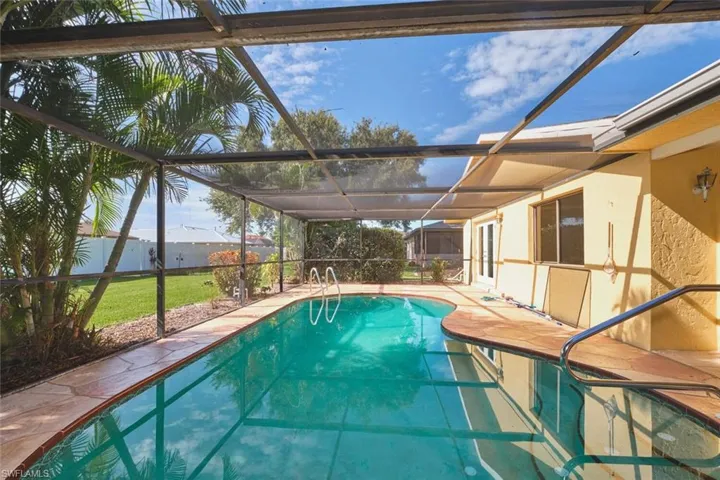 Full view of caged in pool. Stamped concrete pavers is appealing.