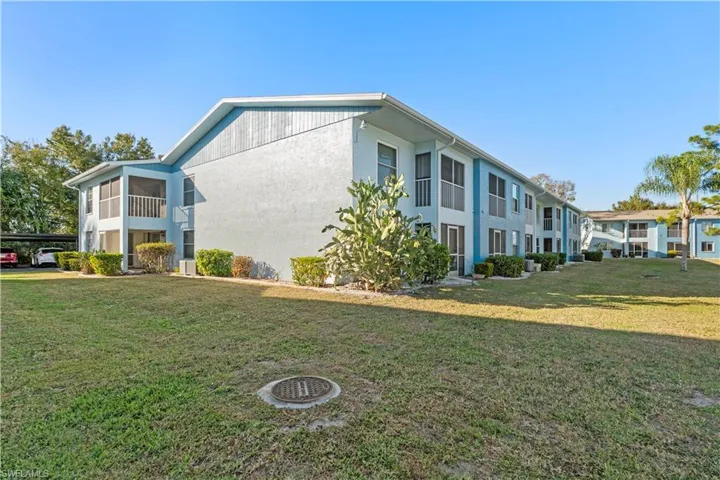 View of side of home featuring a lawn and stucco siding