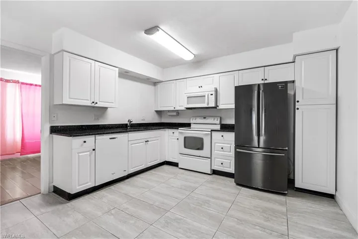 Kitchen with white appliances and white cabinets