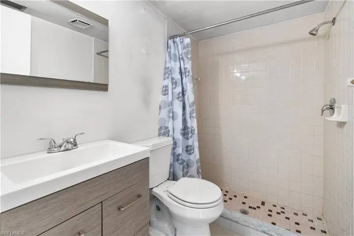 Full bathroom with vanity and a stall shower