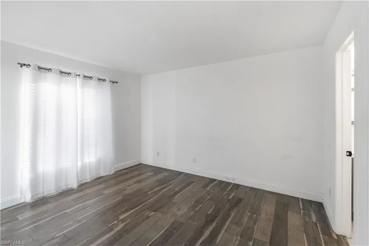 Empty room with dark wood-style floors