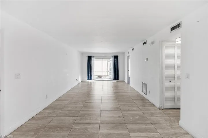 Empty room with light tile patterned flooring and baseboards